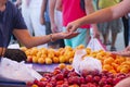 People woman man buying fresh organic apricot at street market. Selling fruits and vegetables in plastic bag, pay money Royalty Free Stock Photo