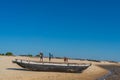 People at a wooden boat cross the river in Morondava harbour.