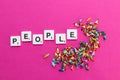 PEOPLE word and miniature people mixed and grouped together chaotically on a bright pink background. Crowd and disorganization and