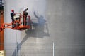 The people at work and paint spraying large container for oil and petrol