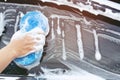 People worker man holding hand blue sponge and bubble foam cleanser window for washing car. Concept car wash clean. Royalty Free Stock Photo