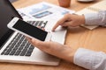 People working from home using smart phone and notebook laptop computer with blank black screen at workplace, anonymous face. Royalty Free Stock Photo