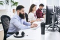 People working in modern IT office. Group of young and experienced programmers and software developers sitting at desks