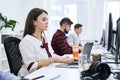 People working in modern IT office. Group of young and experienced programmers and software developers sitting at desks