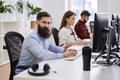 People working in modern IT office. Group of young and experienced programmers and software developers sitting at desks