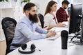 People working in modern IT office. Group of young and experienced programmers and software developers sitting at desks
