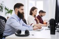 People working in modern IT office. Group of young and experienced programmers and software developers sitting at desks Royalty Free Stock Photo