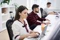 People working in modern IT office. Group of young and experienced programmers and software developers sitting at desks