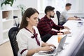 People working in modern IT office. Group of young and experienced programmers and software developers sitting at desks Royalty Free Stock Photo