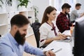 People working in modern IT office. Group of young and experienced programmers and software developers sitting at desks