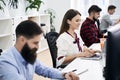 People working in modern IT office. Group of young and experienced programmers and software developers sitting at desks