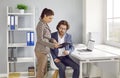 Two employees working in office and looking at some business documents on clipboard Royalty Free Stock Photo