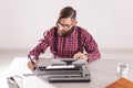 People, world day of writer and hipster concept - young stylish journalist working on typewriter Royalty Free Stock Photo