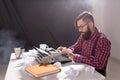 People, writer and hipster concept - young stylish writer working on typewriter Royalty Free Stock Photo