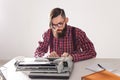 People, writer and hipster concept - young stylish writer working on typewriter Royalty Free Stock Photo