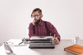 People, writer and hipster concept - young stylish writer working on typewriter Royalty Free Stock Photo