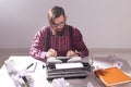 People, writer and hipster concept - young stylish writer working on typewriter Royalty Free Stock Photo