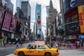 People and a yellow cab at the Times Square in the city of New York, USA. Times square is one of the most famous landmarks in the Royalty Free Stock Photo