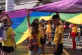 People in yellow t-shirts standing under giant LGBT rainbow flag during the Gay Pride Parade 2018.