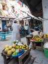 People in Zanzibar town street with vegetable sale on the corner