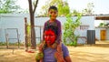 Attractive facial shot of young adult with red smeared color. Indian father and little kid on festival of Holi Royalty Free Stock Photo