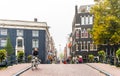 Peoples riding a bicycle in Amsterdam City Center. Beautiful view of Amsterdam Street with Bridge and typical Dutch Houses Royalty Free Stock Photo