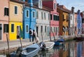 2 people walking - Houses of Burano and reflection in the water. Waterways with traditional boats and colorful facade. Venice - It Royalty Free Stock Photo