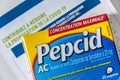 Pepcid AC antacid medicine in front of a Covid-19 prevention document in french language