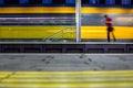 Pepople in a trainstation with motion blurred trains moving fast