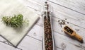 Pepper mill with fresh rosemary and kitchen towel on the wooden table. Food cooking background Royalty Free Stock Photo