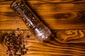 Pepper mill and scattered spices on the wooden table. Top view Royalty Free Stock Photo
