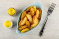 Pepper and salt, blue plate with slices of fried potato, fork on table. Top view Royalty Free Stock Photo