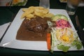 Pepper steak under a peppercorn sauce with fries and vegetable salad Royalty Free Stock Photo