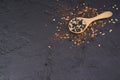 Pepper in a wooden spoon And cayenne pepper scattered on a black table top view Royalty Free Stock Photo