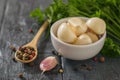 Pepper in a wooden spoon and peeled garlic in a bowl on a wooden table. Component of traditional medicine. Royalty Free Stock Photo