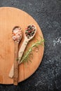 peppercorns and sea salt on a wooden board, vertical image. top view. place for text Royalty Free Stock Photo