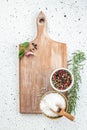 peppercorns and sea salt on a wooden board, vertical image. top view. place for text Royalty Free Stock Photo