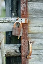 Peppered with dents padlock securing an old wooden door Royalty Free Stock Photo