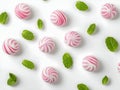 peppermint candies and mint leaves arranged in a repeating pattern on a white background, creating a visually appealing and Royalty Free Stock Photo