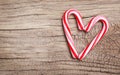 Peppermint Candy Canes in Heart Shape on wooden background. Royalty Free Stock Photo