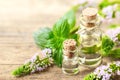 Peppermint essential oil and peppermint flowers on the wooden board