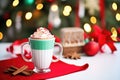 peppermint mocha with a red ribbon tied around the cup, placed beside a holiday card