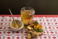 Peppermint tea, with ginger, lemon and turmeric, with pieces of ginger and turmeric on the table, bee honey to sweeten it, on a pi Royalty Free Stock Photo