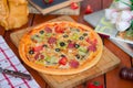 Pepperoni pizza with bell pepper, tomato slices, mushroom and olives.