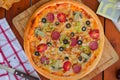 Pepperoni pizza with bell pepper, tomato slices, mushroom and olives.