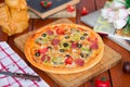 Pepperoni pizza with bell pepper, tomato slices, mushroom and olives.