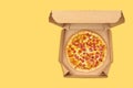 Pepperoni pizza in brown take-out box on yellow background Royalty Free Stock Photo