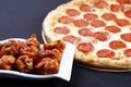 Pepperoni pizza with chicken wings