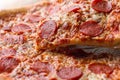 Pepperoni pizza with one slice cut off Royalty Free Stock Photo
