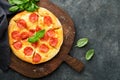 Pepperoni pizza. Traditional pepperoni pizza and cooking ingredients tomatoes basil on old concrete texture background table Royalty Free Stock Photo